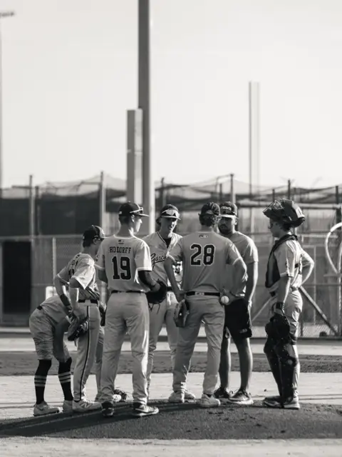 GBG Colorado 2027 players and coach huddled at the mound