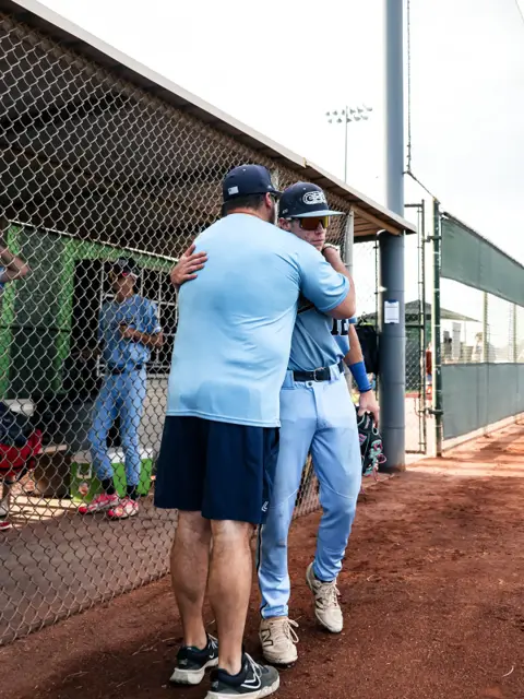 GBG Colorado coach with an arm around a player leaving the dugout