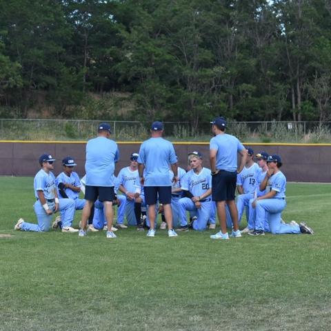 GBG Colorado coaches and players huddled in the outfield